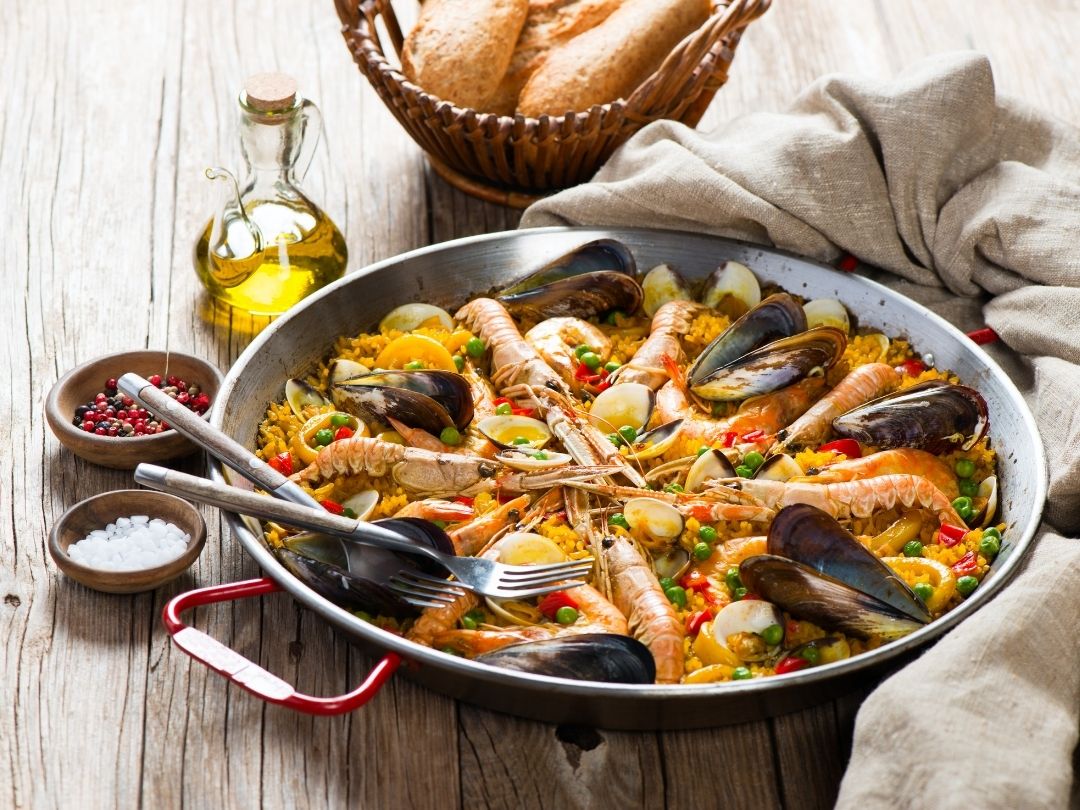 Spanische Paella in der typischen Paella Pfanne zubereitet und serviert